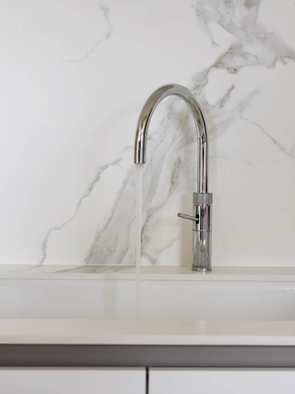 Tap for kitchen sink with marble porcelain splashback